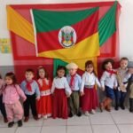No rincão vizinho, os pequenos gaúchos da EMEI Maria Veni Lottermann estão aprendendo o valor das tradições com um chimarrão feito de filtro de café e um baile que deixaria qualquer CTG de bombacha arriada